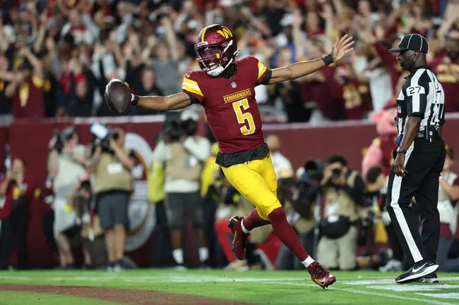Aug 18, 2025; Landover, Maryland, USA; Washington Commanders quarterback Jayden Daniels (5) celebrates after scoring a touchdown against Cincinnati Bengals during the first half at Northwest Stadium. Mandatory Credit: Amber Searls-Imagn Images