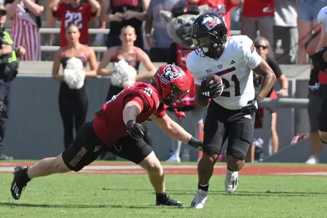featured-image-1759248681961 Sep 28, 2024; Raleigh, North Carolina, USA; Northern Illinois cornerback Dev'ion Reynolds (21) runs the ball against North Carolina State Wolfpack linebacker Caden Fordham (10) at Carter-Finley Stadium. Mandatory Credit: Zachary Taft-Imagn Images