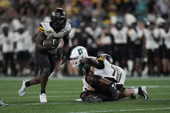 featured-image-1759251615158 Aug 29, 2025; Charlotte, North Carolina, USA; Appalachian State Mountaineers running back Rashod Dubinion (7) runs around a block by Appalachian State Mountaineers offensive lineman Tyriq Poindexter (78) during the second quarter against the Charlotte 49ers at Bank of America Stadium. Mandatory Credit: Jim Dedmon-Imagn Images