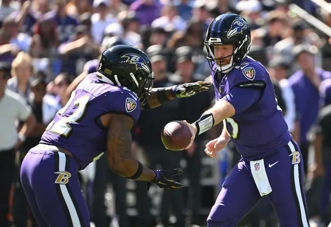 Oct 5, 2025; Baltimore, Maryland, USA; Baltimore Ravens quarterback Cooper Rush (15) hands the ball off to running back Derrick Henry (22) during the first quarter against the Houston Texans at M&T Bank Stadium. Mandatory Credit: Rafael Suanes-Imagn Images