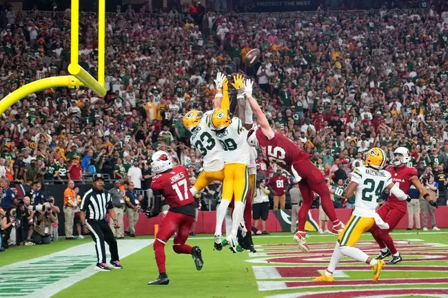 Oct 19, 2025; Glendale, Arizona, USA; Arizona Cardinals and Green Bay Packers players go for a jump ball on the final play of the game during the second half at State Farm Stadium. Mandatory Credit: Joe Camporeale-Imagn Images