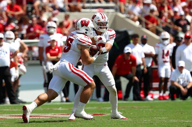 Sep 13, 2025; Tuscaloosa, Alabama, USA; Wisconsin Badgers quarterback Danny O'Neil (18) hands the ball off to running back Cade Yacamelli (25) during the second half against the Alabama Crimson Tide at Saban Field at Bryant-Denny Stadium. Mandatory Credit: David Leong-Imagn Images