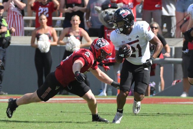 Sep 28, 2024; Raleigh, North Carolina, USA; Northern Illinois cornerback Dev'ion Reynolds (21) runs the ball against North Carolina State Wolfpack linebacker Caden Fordham (10) at Carter-Finley Stadium. Mandatory Credit: Zachary Taft-Imagn Images