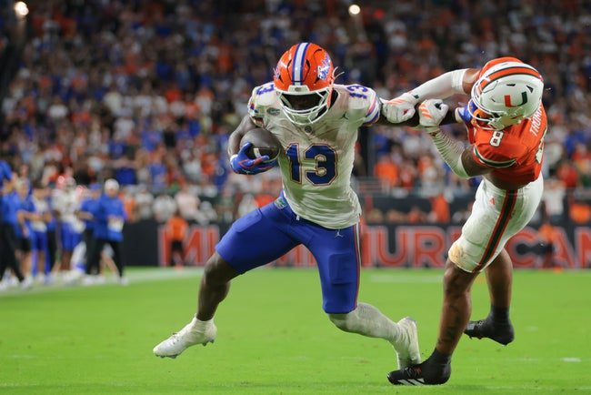 Sep 20, 2025; Miami Gardens, Florida, USA; Florida Gators running back Jadan Baugh (13) carries the football against Miami Hurricanes defensive back Jakobe Thomas (8) during the third quarter at Hard Rock Stadium. Mandatory Credit: Sam Navarro-Imagn Images