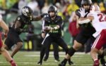 Oct 25, 2025; Eugene, Oregon, USA; Oregon Ducks quarterback Brock Thomas (12) hands off the football during the second half to running back Jordon Davison (0) against the Wisconsin Badgers at Autzen Stadium. Mandatory Credit: Troy Wayrynen-Imagn Images