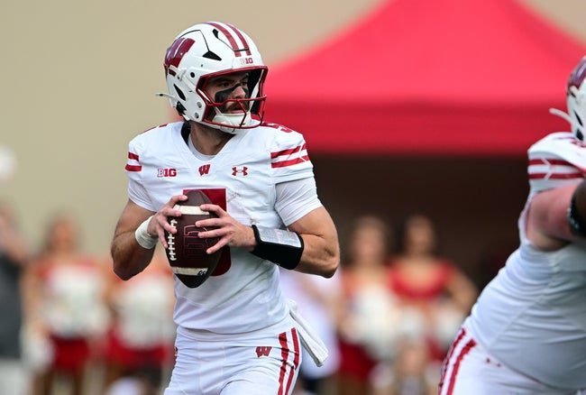 Nov 15, 2025; Bloomington, Indiana, USA; Wisconsin Badgers quarterback Carter Smith (5) looks for an open teammate during the first quarter against the Indiana Hoosiers at Memorial Stadium. Mandatory Credit: Marc Lebryk-Imagn Images