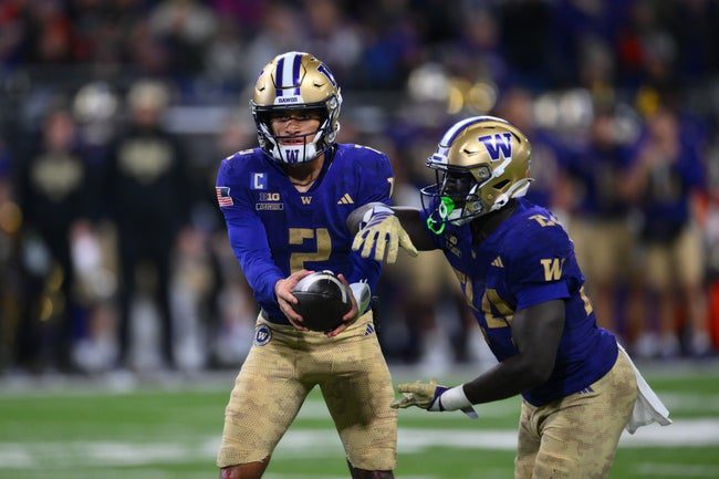 Nov 15, 2025; Seattle, Washington, USA; Washington Huskies quarterback Demond Williams Jr. (2) hands the ball to running back Adam Mohammed (24) during the first half against the Purdue Boilermakers at Husky Stadium. Mandatory Credit: Steven Bisig-Imagn Images