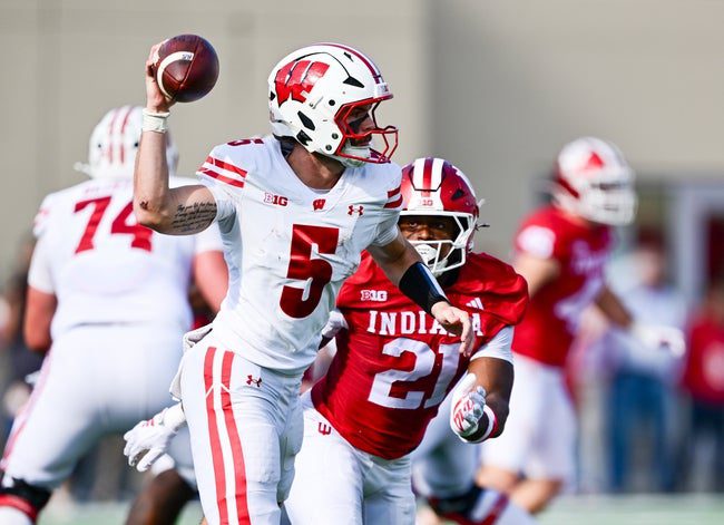 Nov 15, 2025; Bloomington, Indiana, USA; Wisconsin Badgers quarterback Carter Smith (5) throws a pass in front of Indiana Hoosiers linebacker Rolijah Hardy (21) during the second quarter at Memorial Stadium. Mandatory Credit: Marc Lebryk-Imagn Images