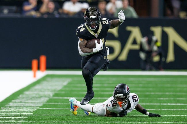 Nov 23, 2025; New Orleans, Louisiana, USA; New Orleans Saints running back Devin Neal (24) jumps over Atlanta Falcons cornerback Dee Alford (20) as he carries the ball during the second half at Caesars Superdome. Mandatory Credit: Stephen Lew-Imagn Images