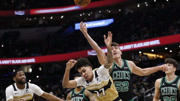 Dec 4, 2025; Washington, District of Columbia, USA; Boston Celtics center Luka Garza (52) reaches over Washington Wizards guard Will Riley (27) for a rebound in the second half at Capital One Arena. Mandatory Credit: Geoff Burke-Imagn Images