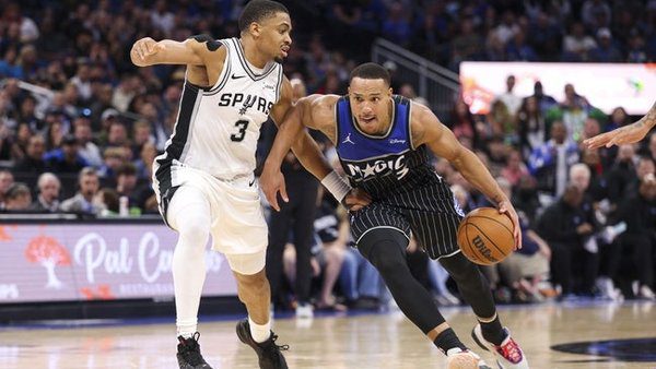 Dec 3, 2025; Orlando, Florida, USA; Orlando Magic guard Desmond Bane (3) drives to the basket past San Antonio Spurs forward Keldon Johnson (3) in the fourth quarter at Kia Center. Mandatory Credit: Nathan Ray Seebeck-Imagn Images