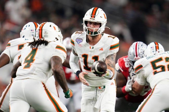 Miami Hurricanes quarterback Carson Beck (11) hands off to running back Mark Fletcher Jr. (4) during the Cotton Bowl at AT&T Stadium in Arlington, Texas for the College Football Playoff quarterfinal game against the Ohio State Buckeyes on Dec. 31, 2025.