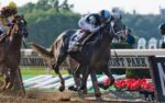 Thoroughbred horses racing down the stretch at Saratoga for the 2026 Belmont Stakes picks and longshots analysis