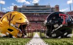 Sun Devils and Red Raiders helmets on the center line at Galaxy Stadium in Lubbock, Texas, beneath a big West Texas sky
